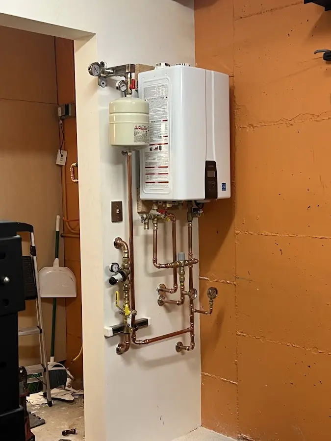 Plumbing technician inspecting water heater connections in La Habra